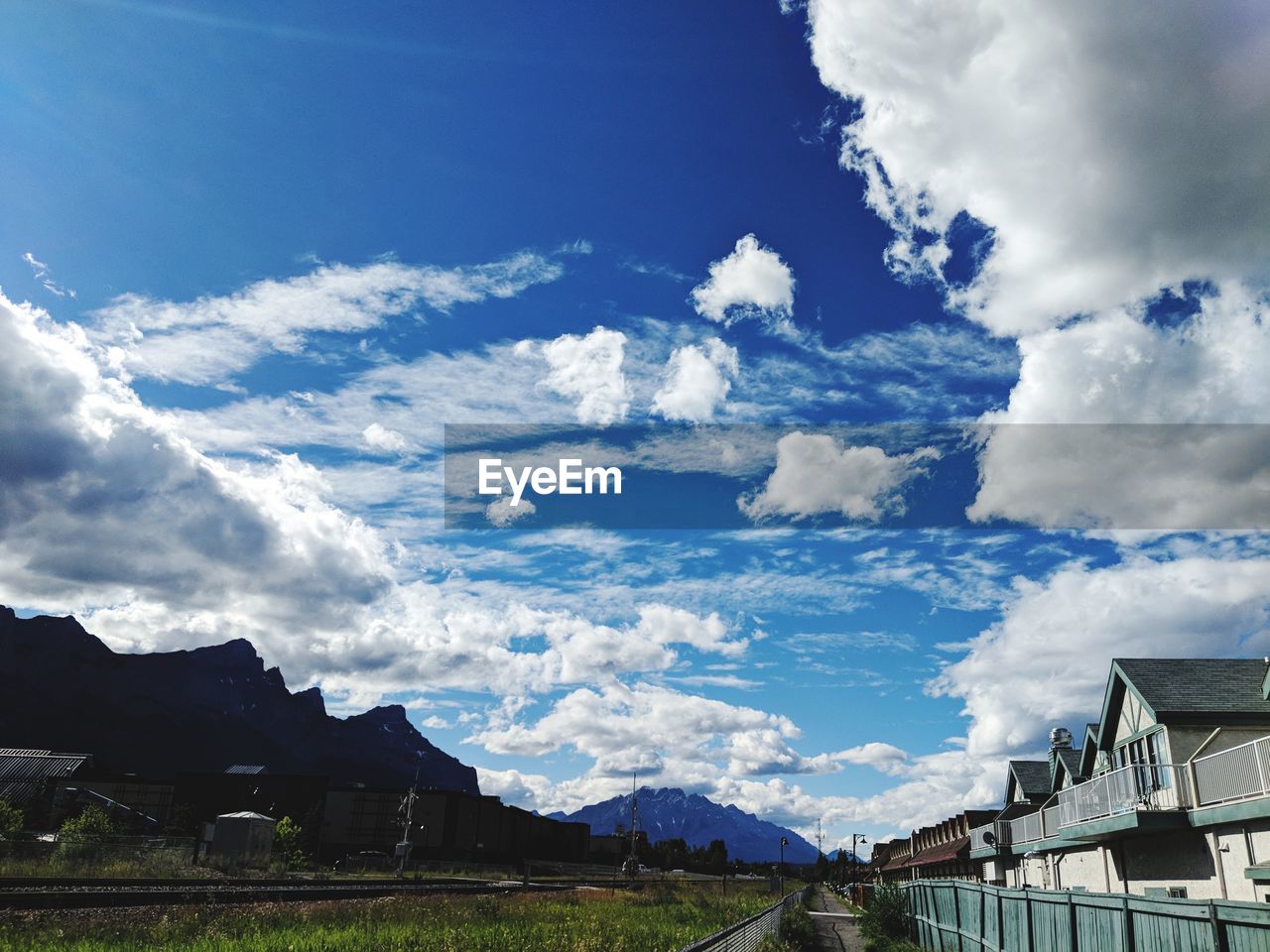 LOW ANGLE VIEW OF HOUSES AND MOUNTAINS AGAINST SKY