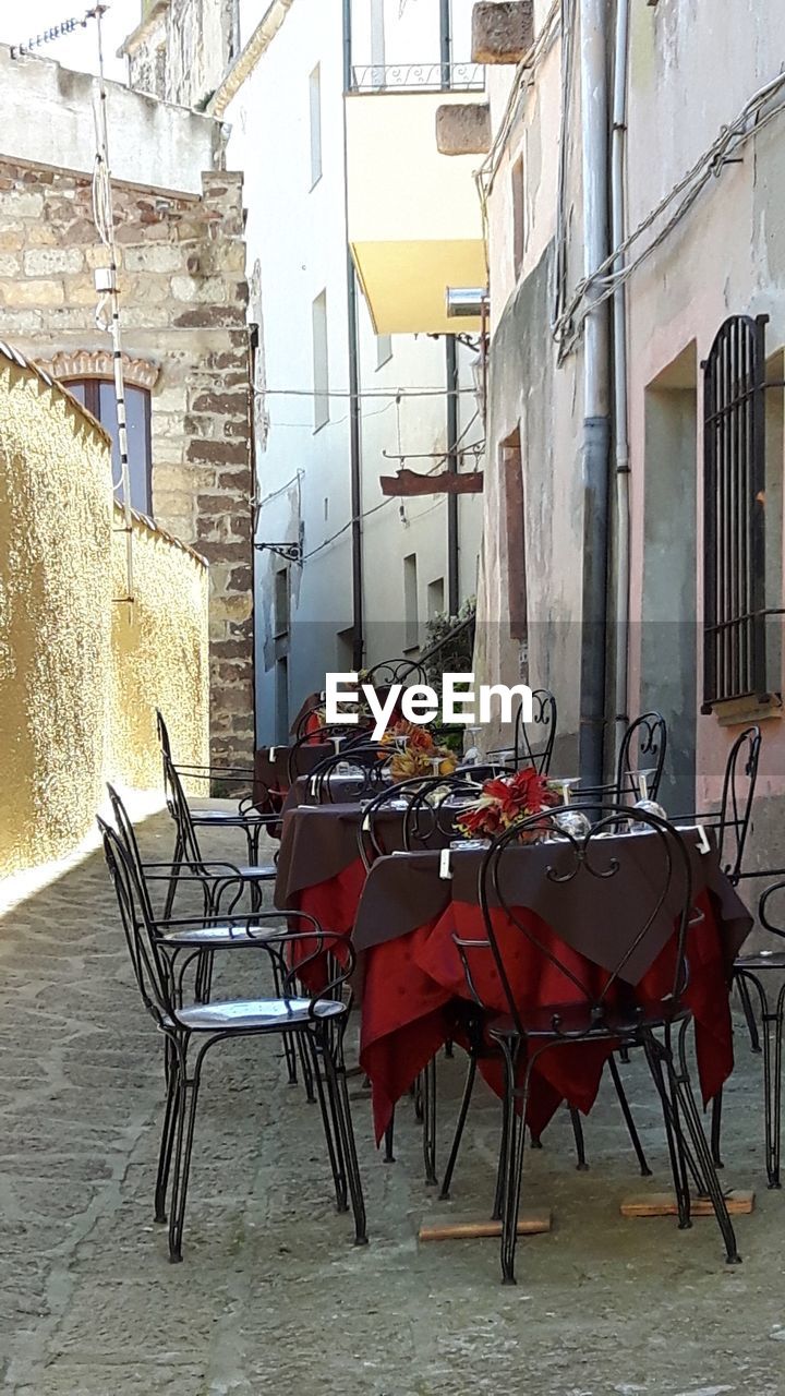 EMPTY CHAIRS AND TABLES IN ALLEY