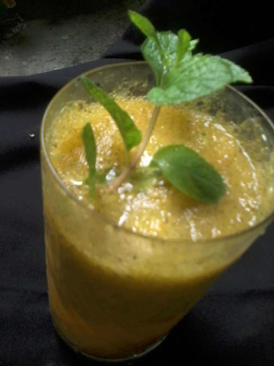 Glass of orange smoothie with fresh mint