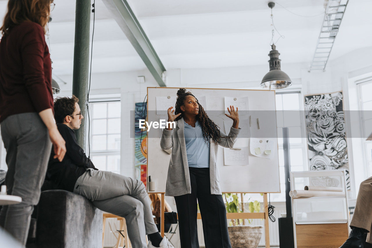 Businesswoman explaining colleagues during meeting at office