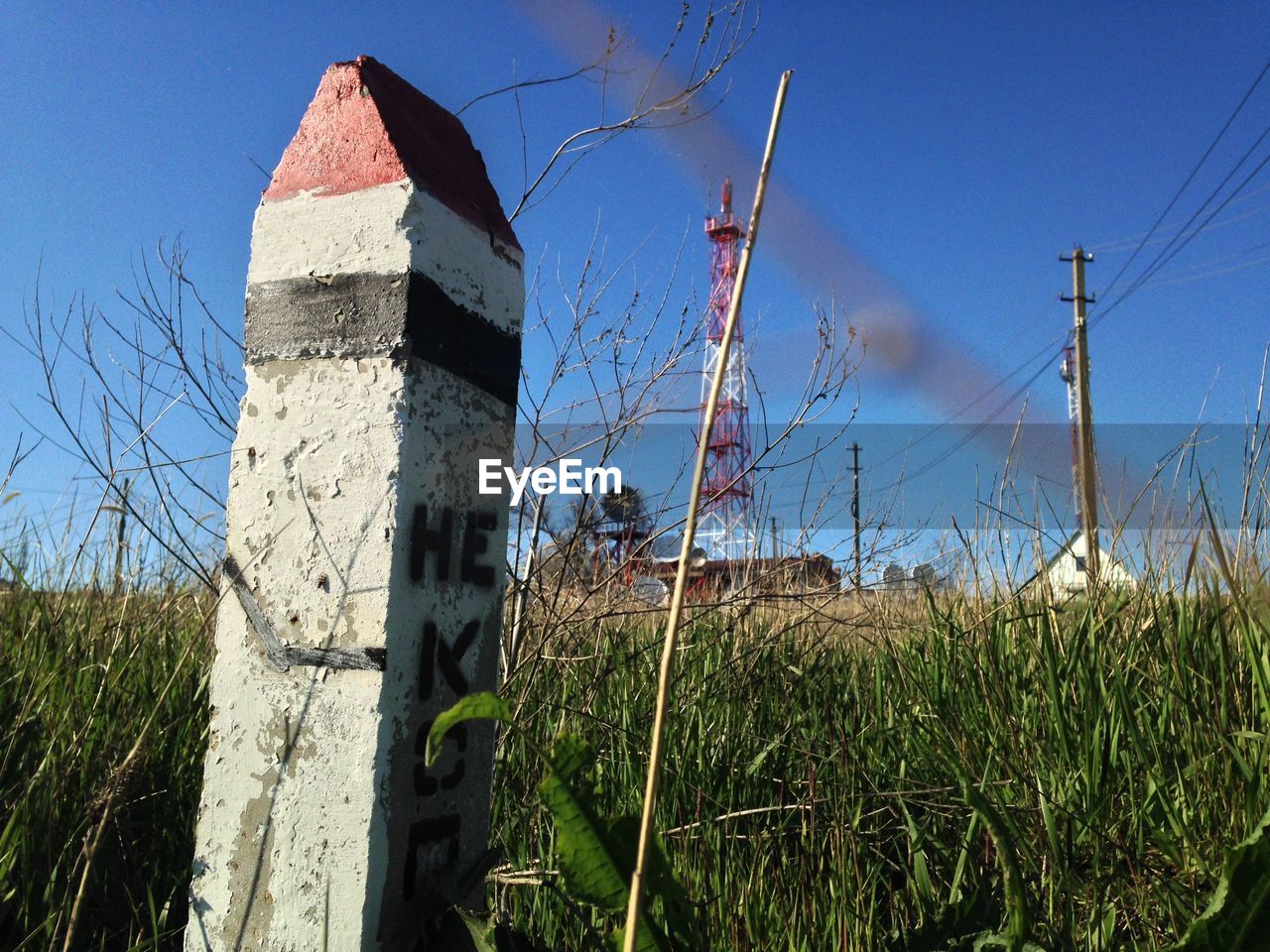 Low angle view of electricity pylon on field against sky