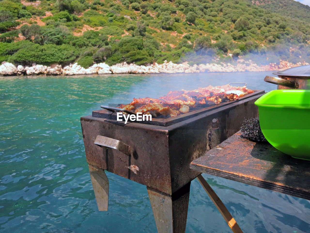 SCENIC VIEW OF BARBECUE GRILL BY LAKE