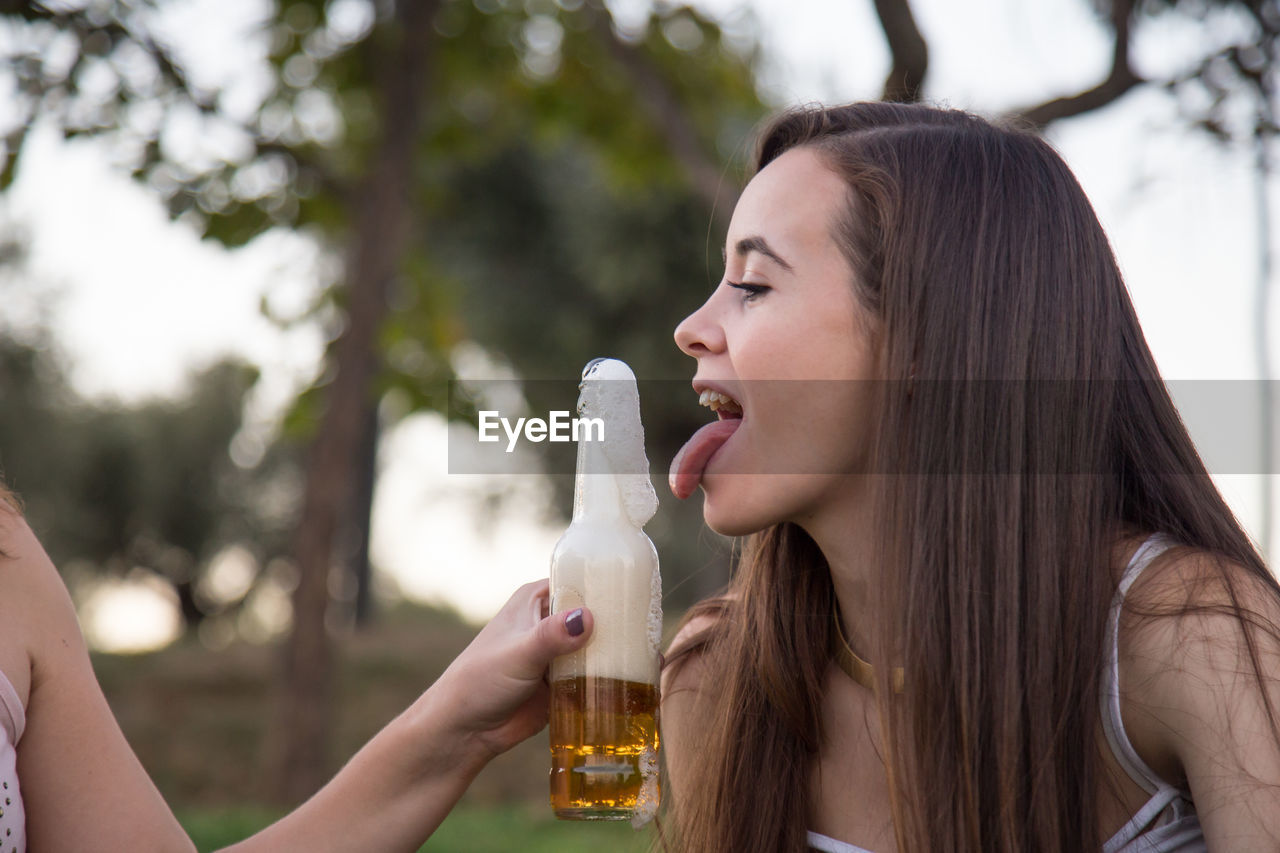 Portrait of happy friends holding beer bottle