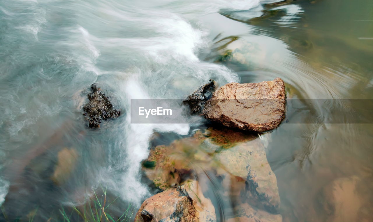 High angle view of waves breaking on rocks