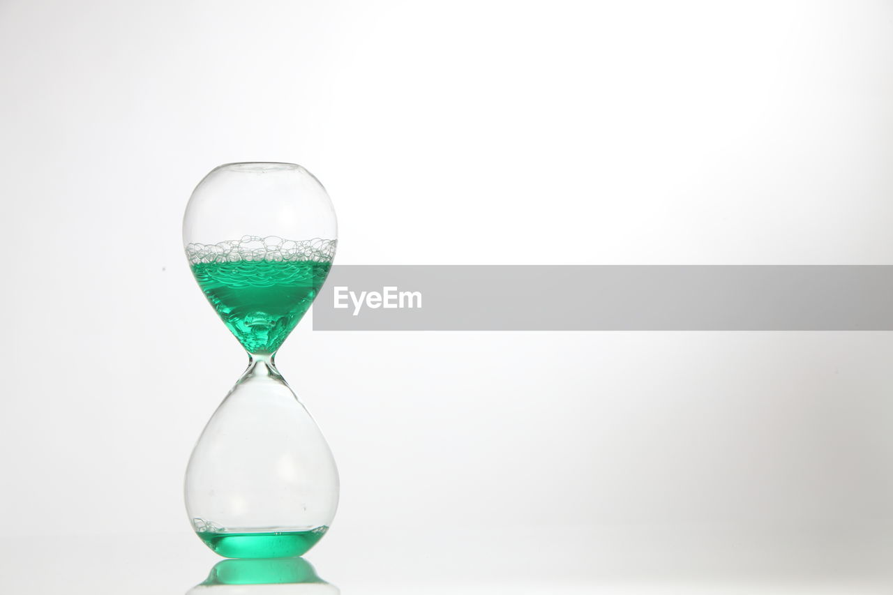 Close-up of hourglass against white background