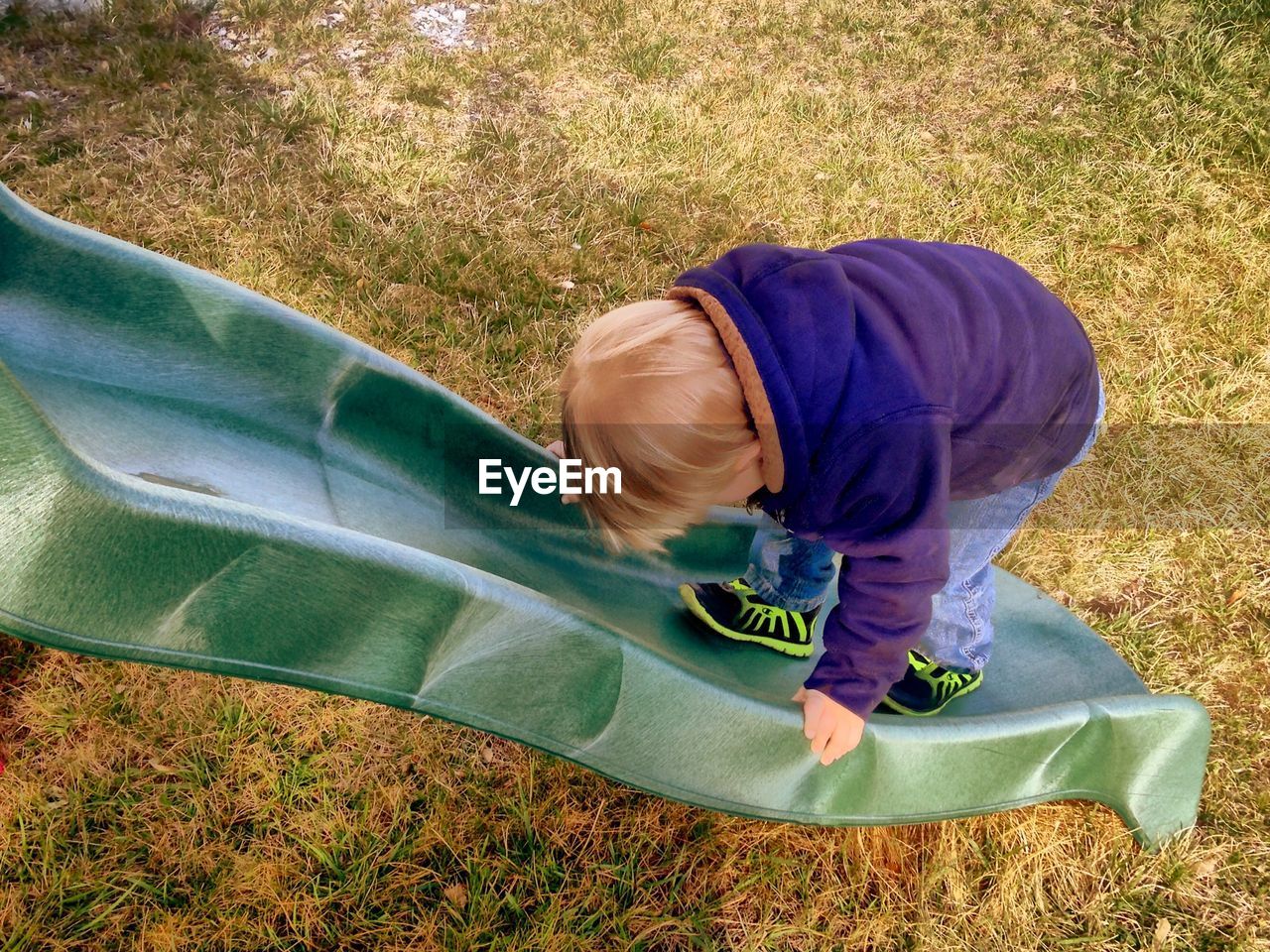 Rear view of boy on slide at park