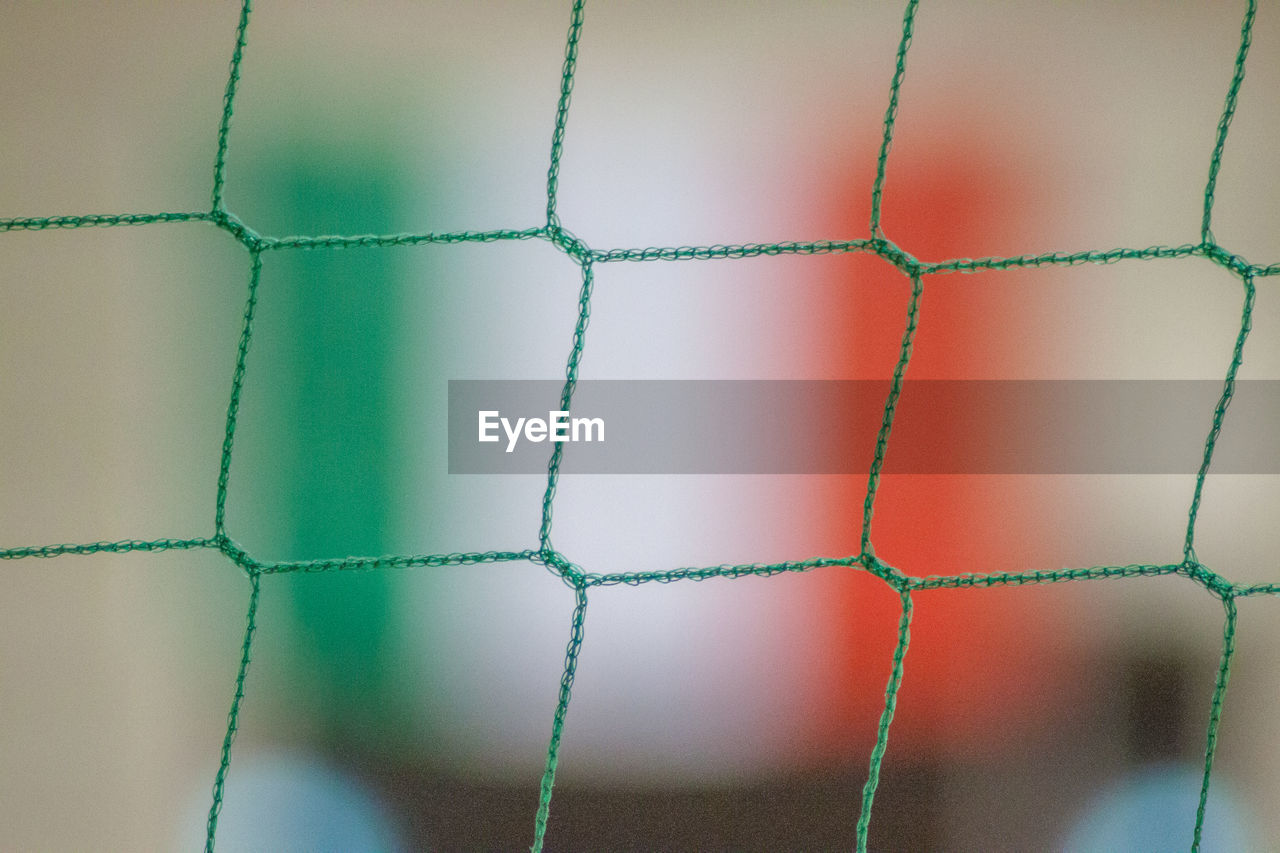 Close-up of green net against italian flag