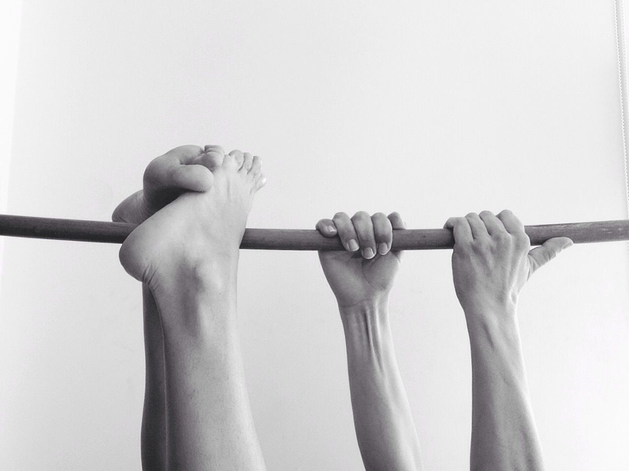 Cropped image of person hanging on pole against white background