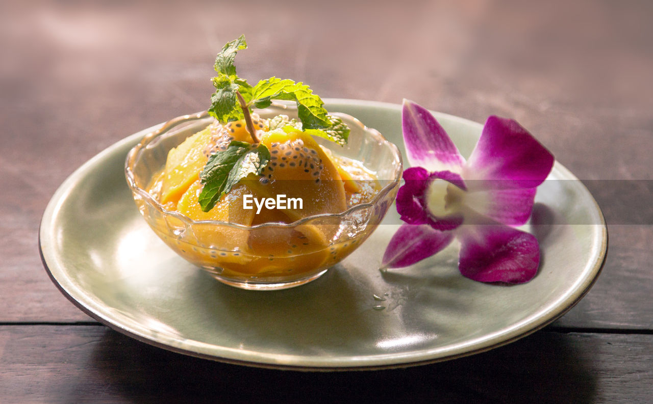 Close-up of mango by flower on table