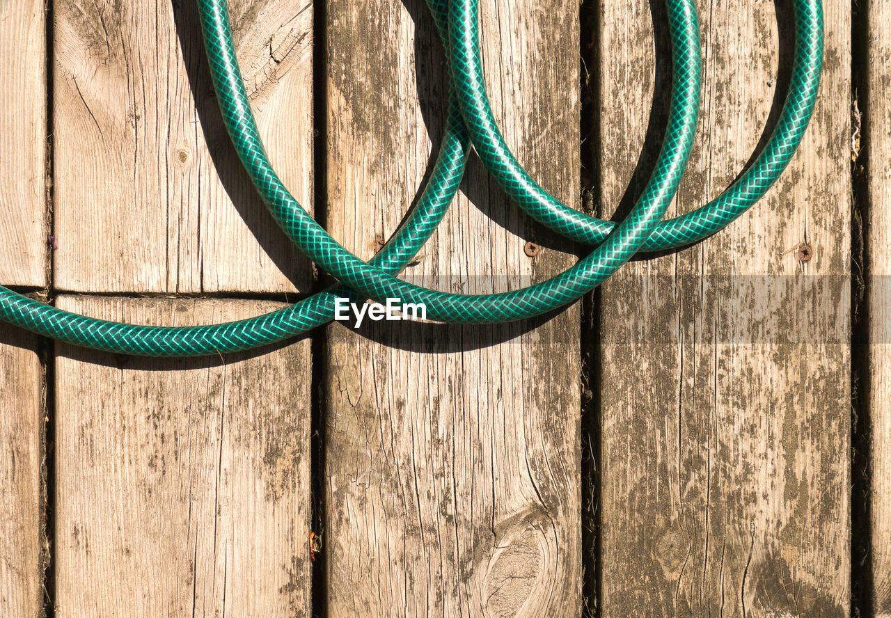 High angle view of garden hose on floorboard