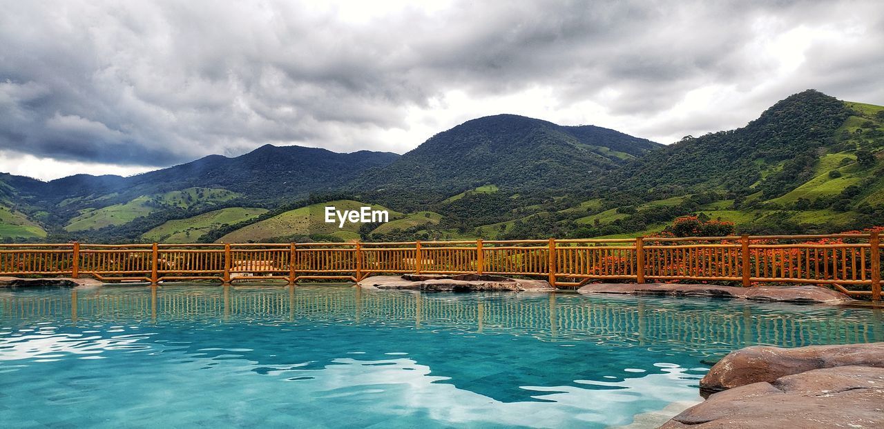 SWIMMING POOL BY MOUNTAINS AGAINST SKY