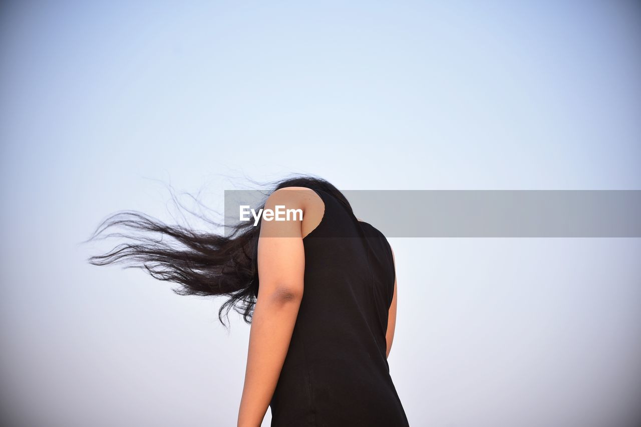 Low section of woman standing against sky