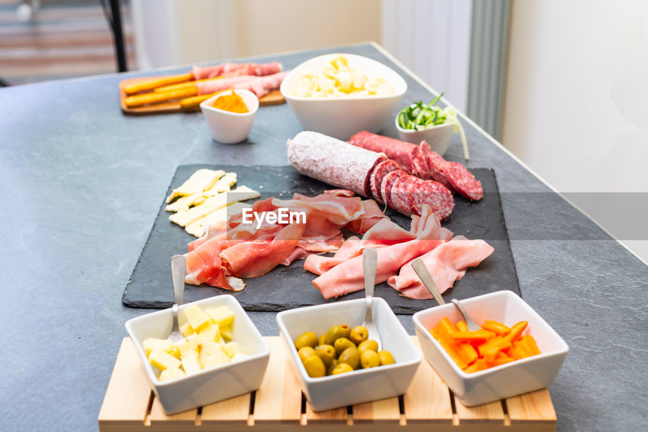 HIGH ANGLE VIEW OF CHOPPED VEGETABLES ON TABLE IN KITCHEN