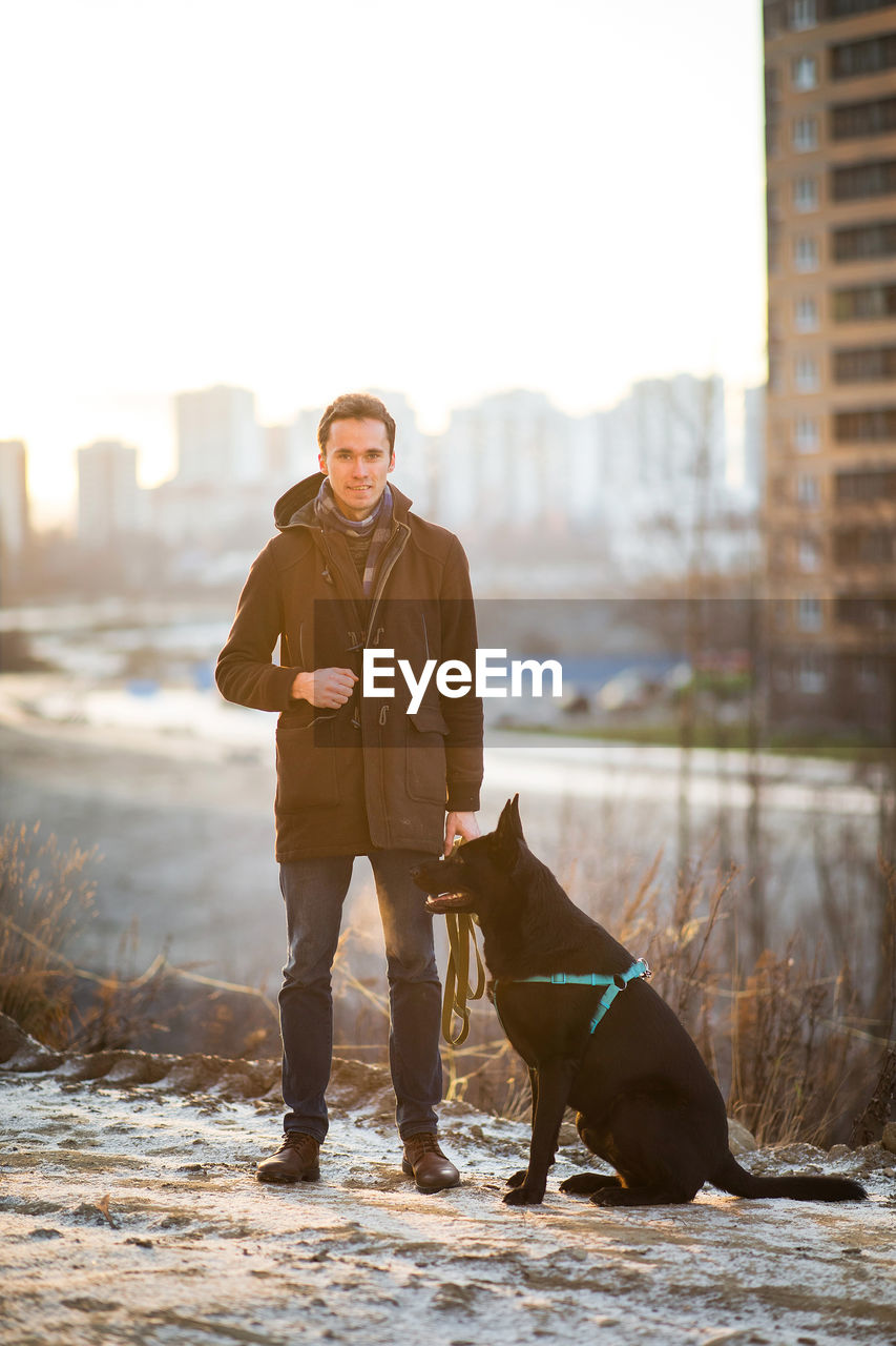 Full length of man standing with dog