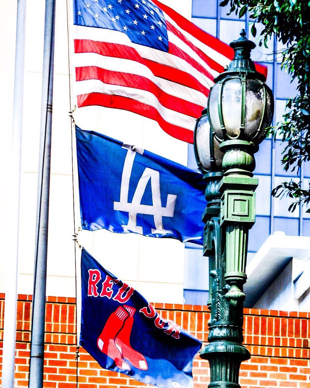 Lamp post against flags waving during sunny day