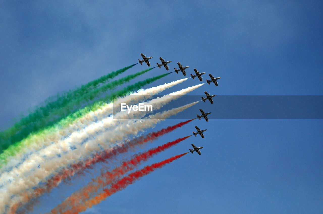 Low angle view of airshow in blue sky