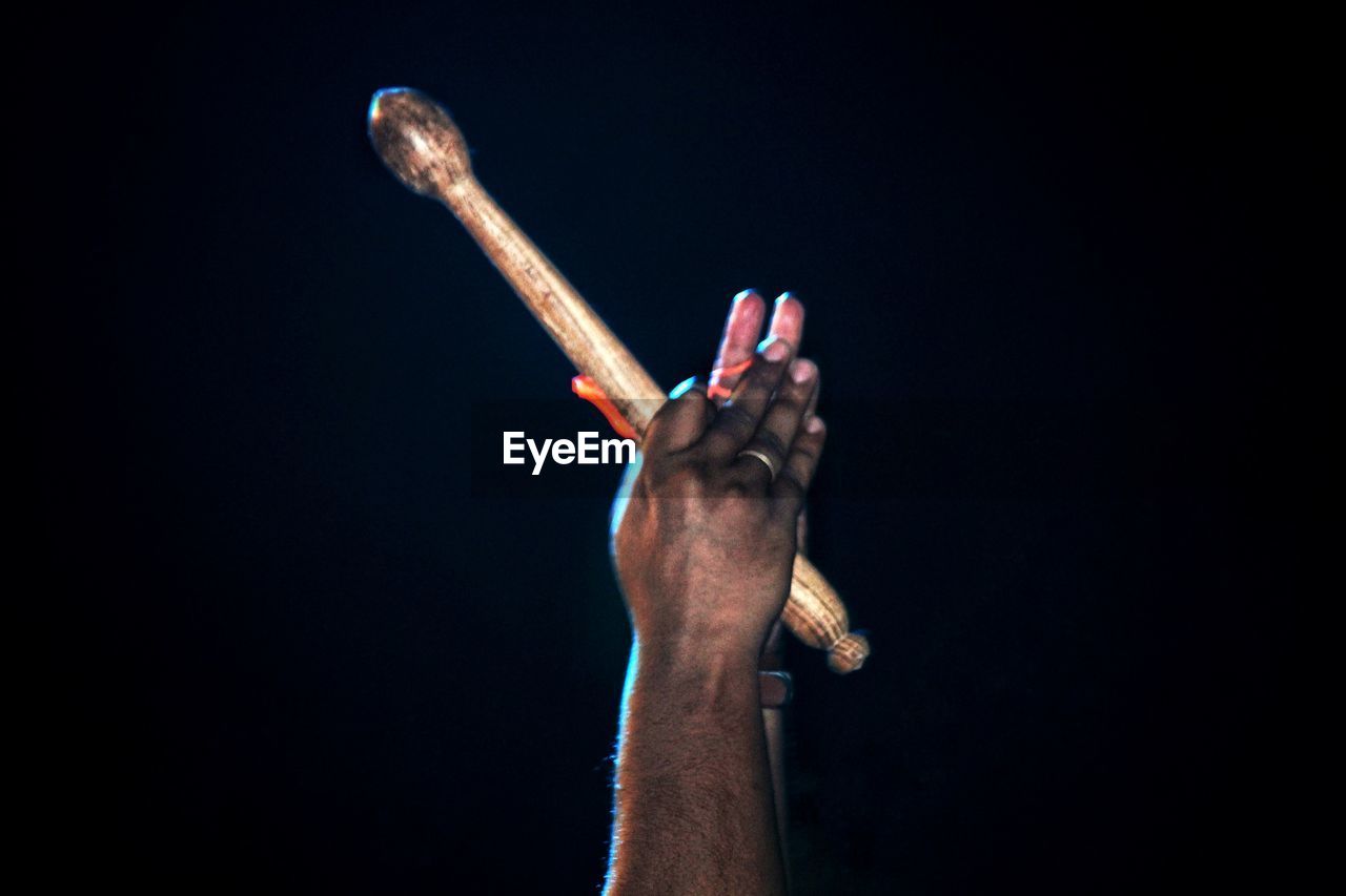 CLOSE-UP OF MAN HAND HOLDING BLACK BACKGROUND