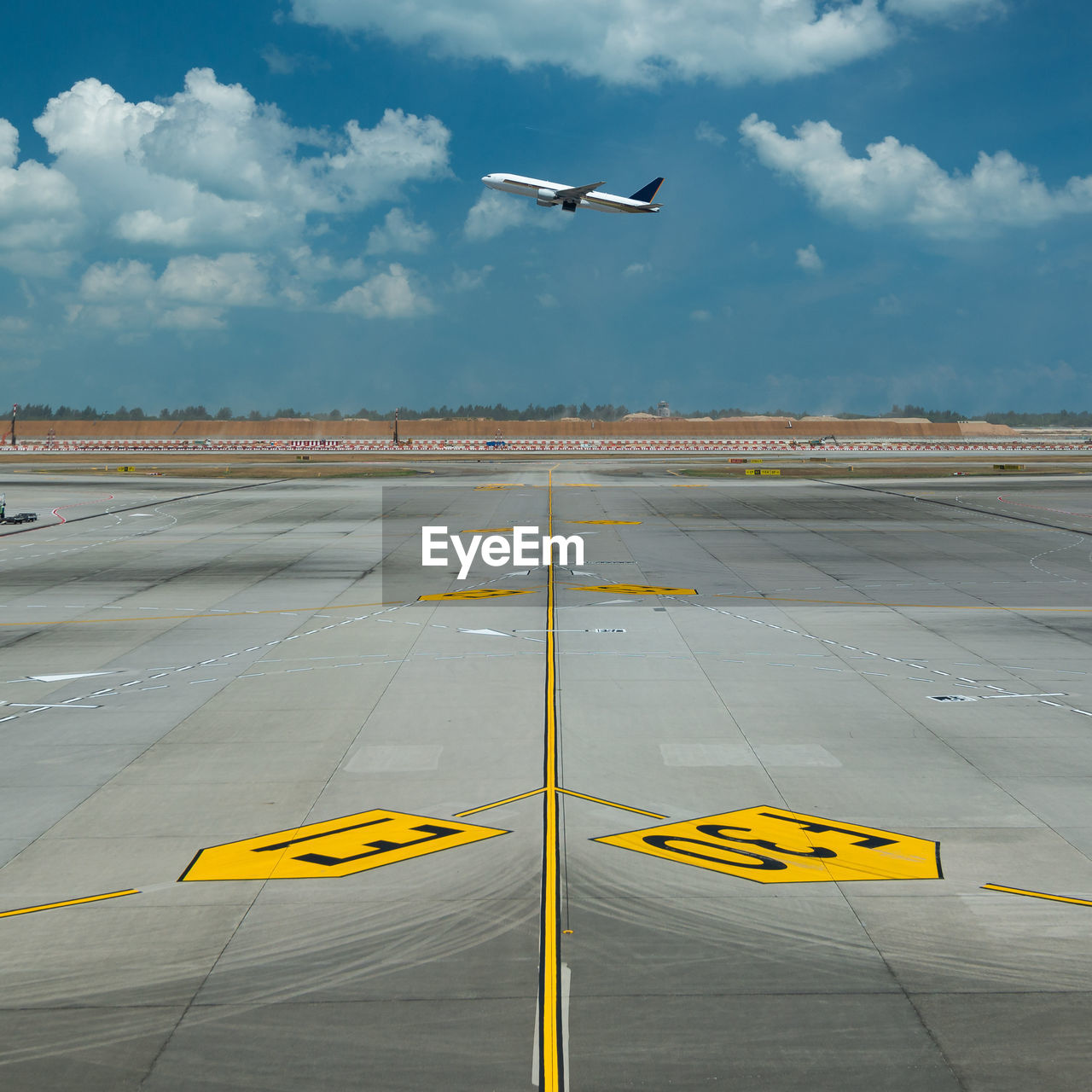 Airplane flying over runway against sky