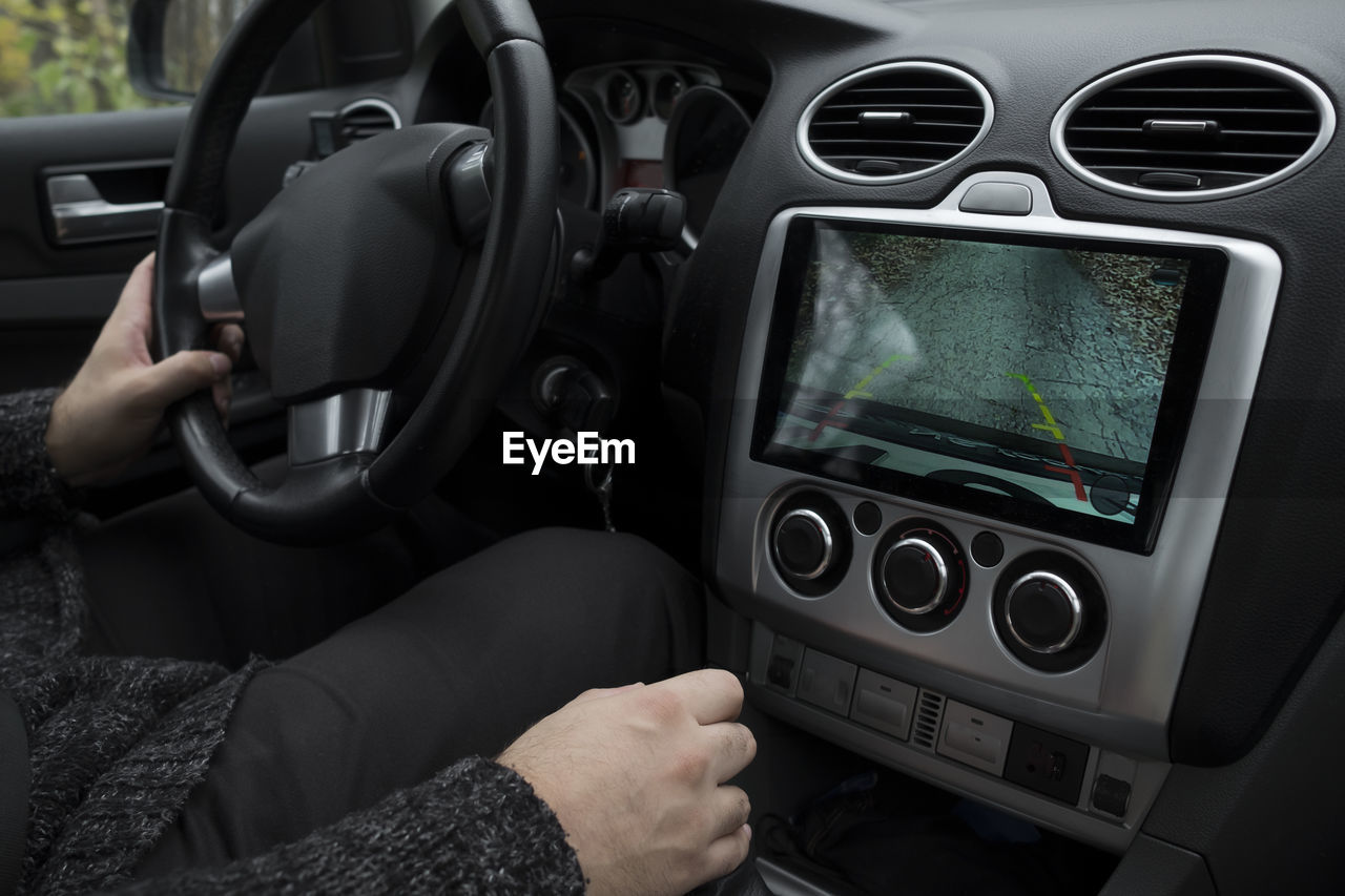 Midsection of man sitting in car