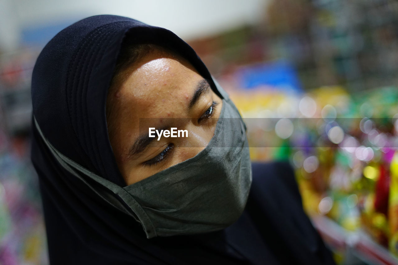 Close-up of woman wearing hijab and mask