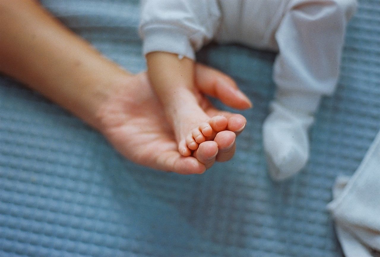 Extreme close up of hand holding baby foot