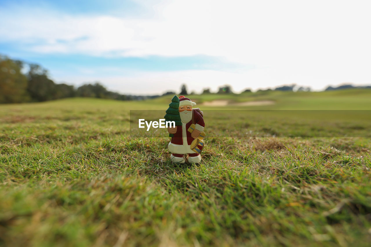 Close-up of santa claus figurine on grassy field