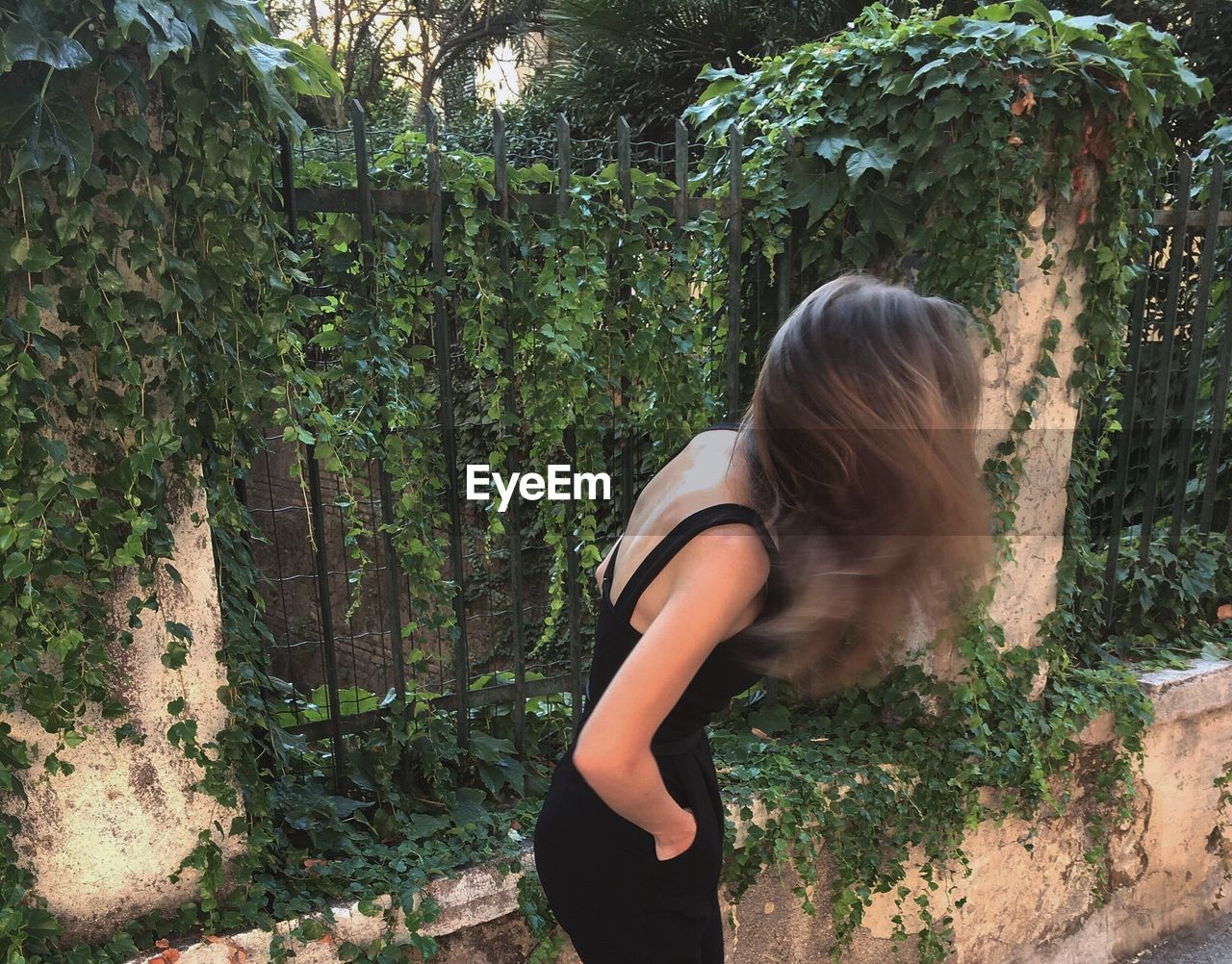 Side view of woman standing by plants
