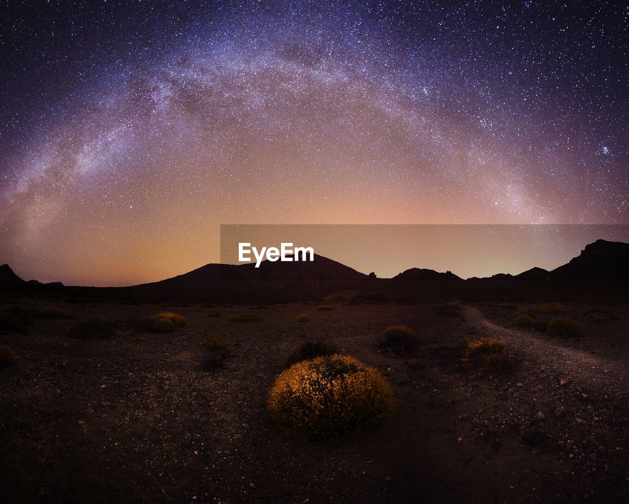 Scenic view of illuminated mountains against sky at night