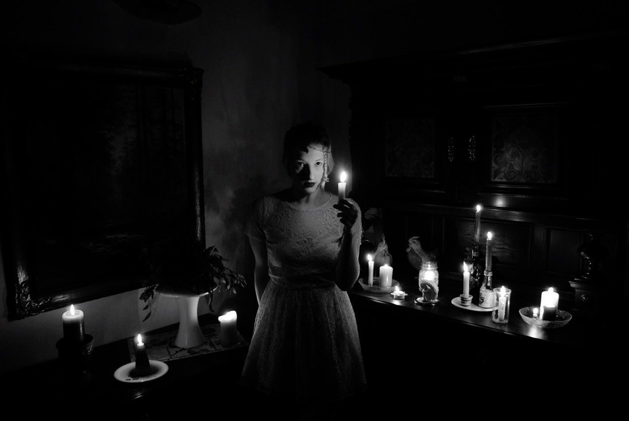 Woman holding illuminated candles in dark