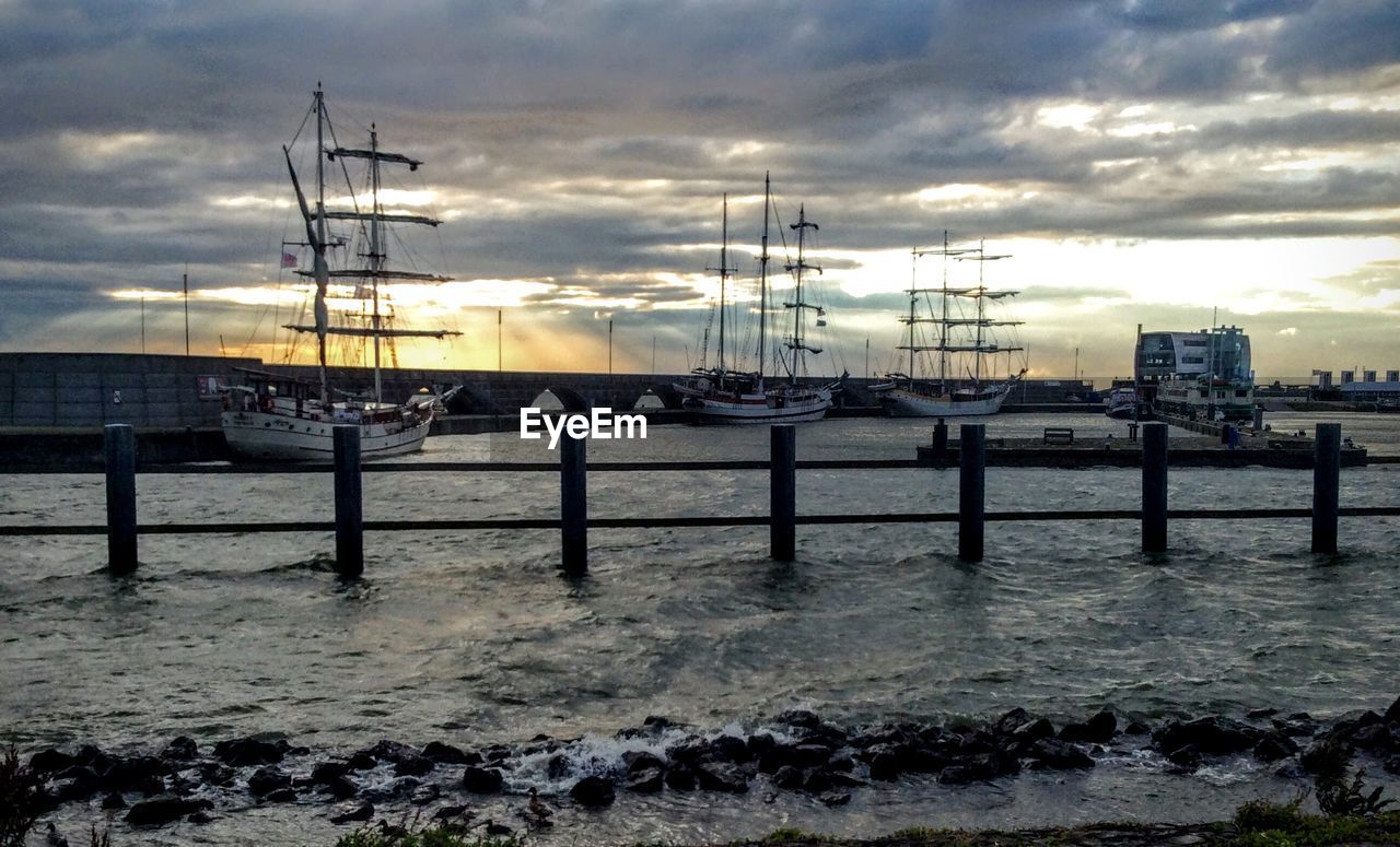 BOATS MOORED AT HARBOR