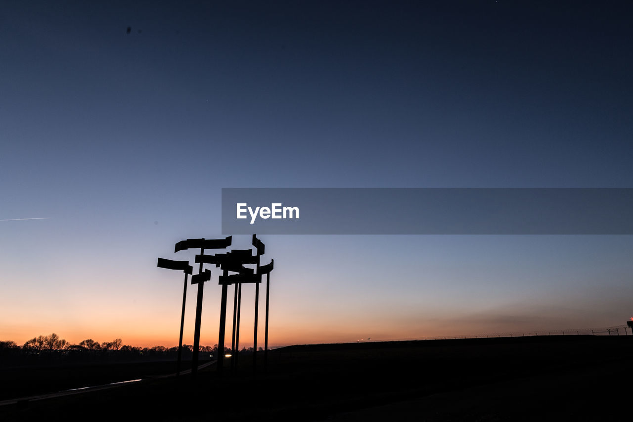 SILHOUETTE CRANE AGAINST CLEAR SKY AT SUNSET