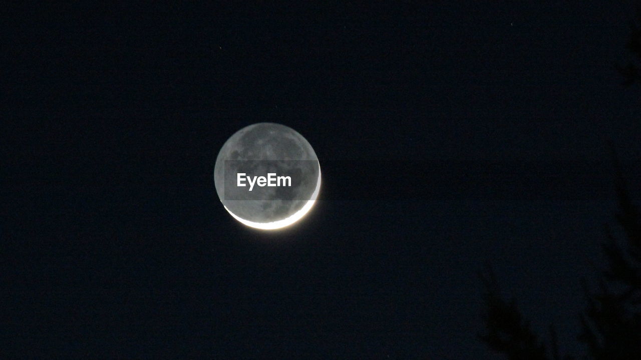 LOW ANGLE VIEW OF MOON IN SKY AT NIGHT