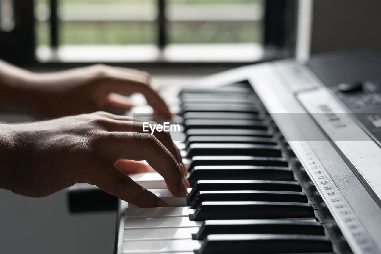 cropped hand of person playing piano