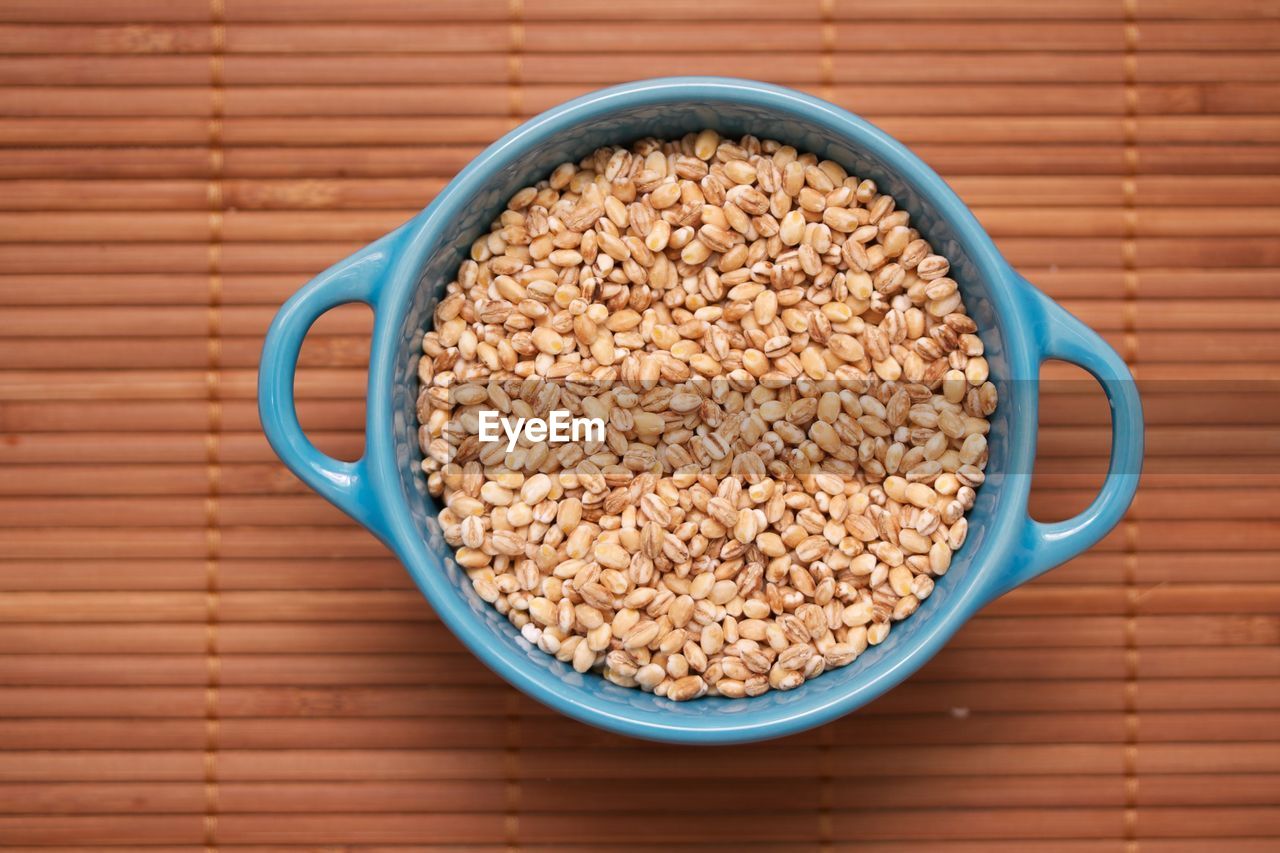 Barley in a blue bowl on a bambu mat