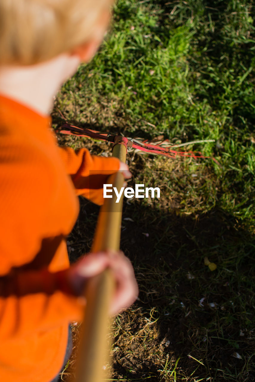Boy holding rake in yard