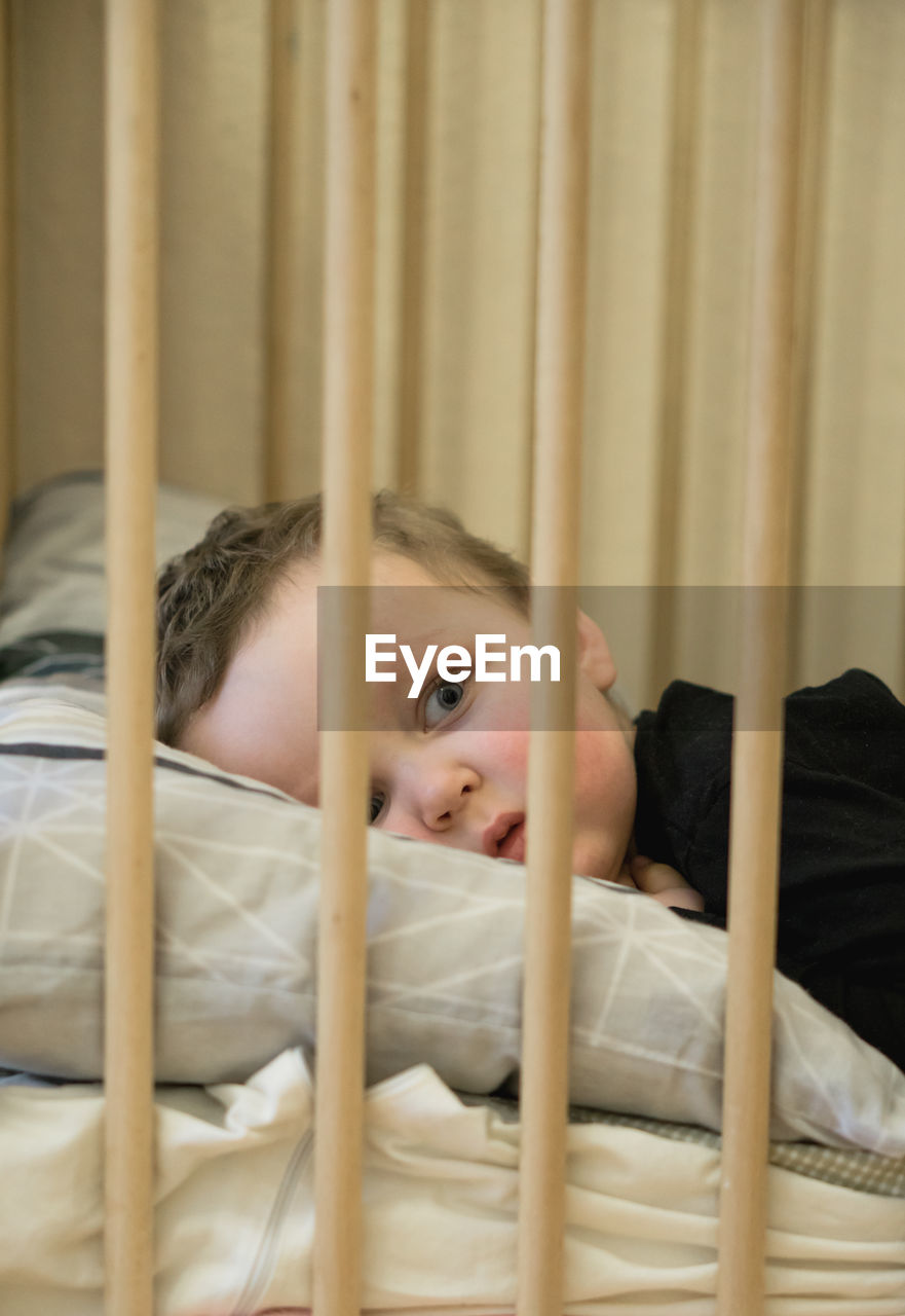 Portrait of cute baby lying on bed