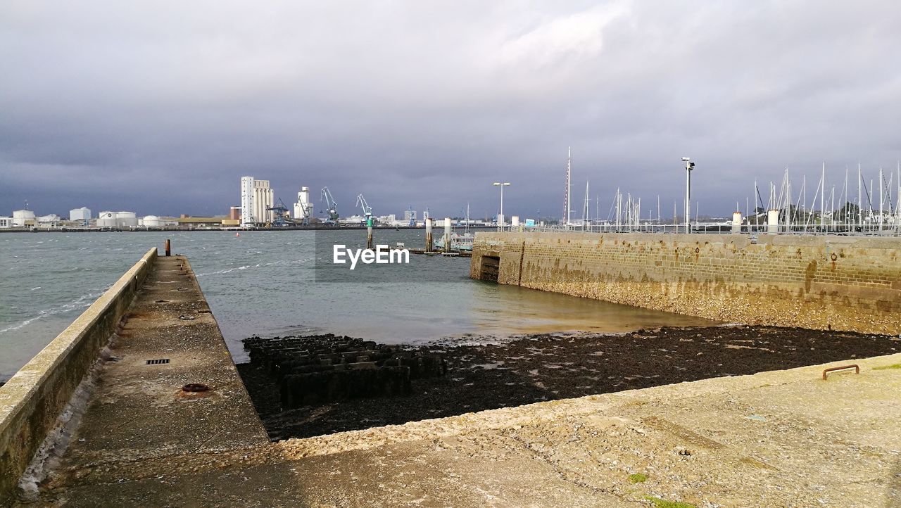 SCENIC VIEW OF HARBOR AGAINST SKY