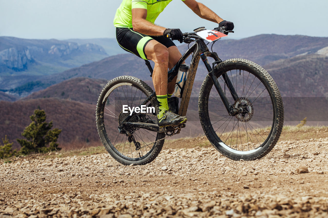 cropped image of man riding bicycle on field