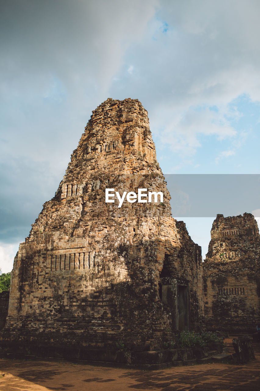 Ancient temple against cloudy sky