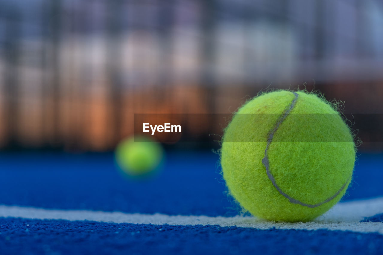 tennis, tennis ball, sports, ball, green, tennis racket, racket, sports equipment, tennis net, close-up, no people, focus on foreground, competition, selective focus, sphere, blue, recreation, day, racket sport, yellow, leisure activity