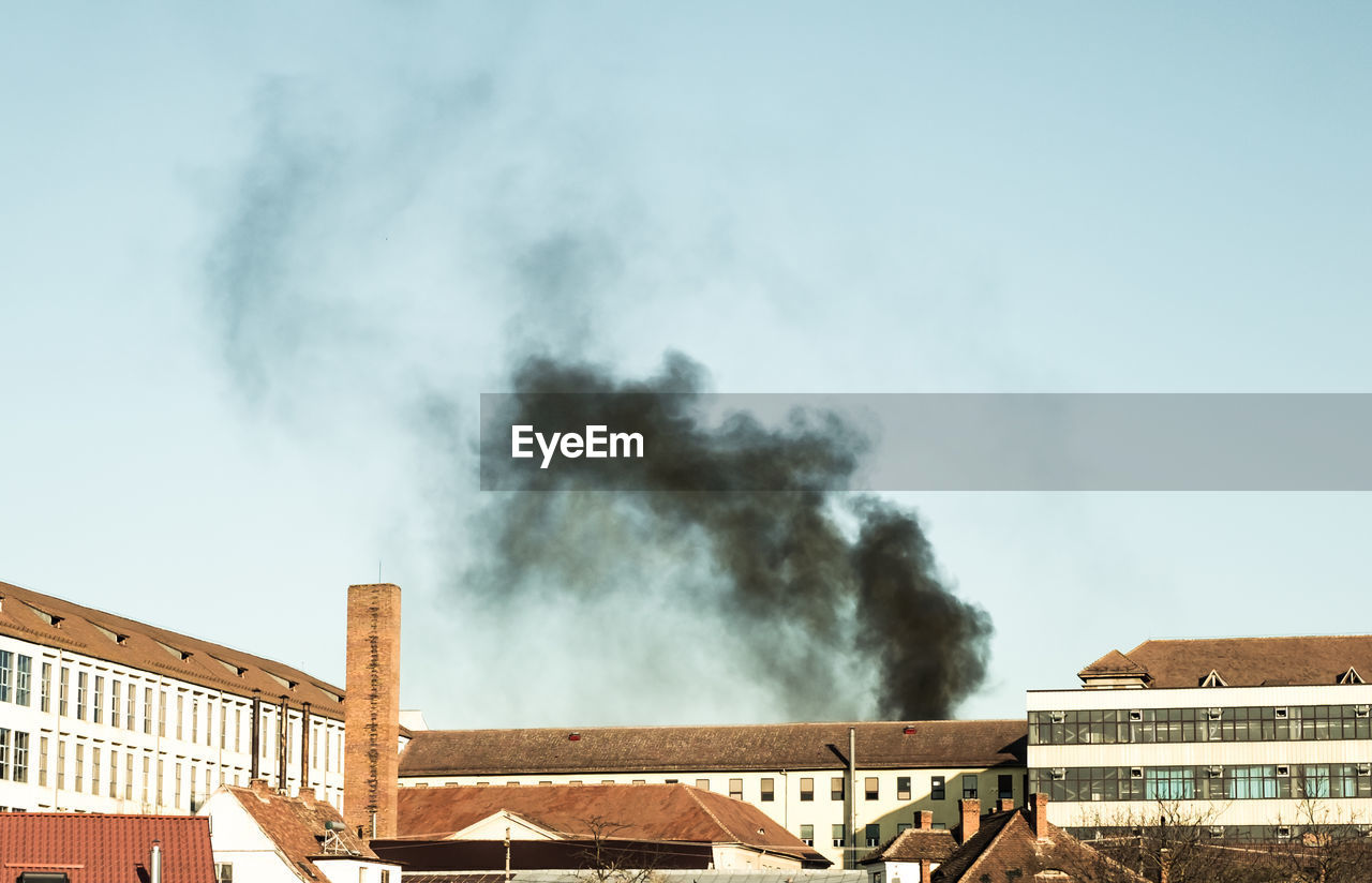 Smoke emitting from chimney against sky