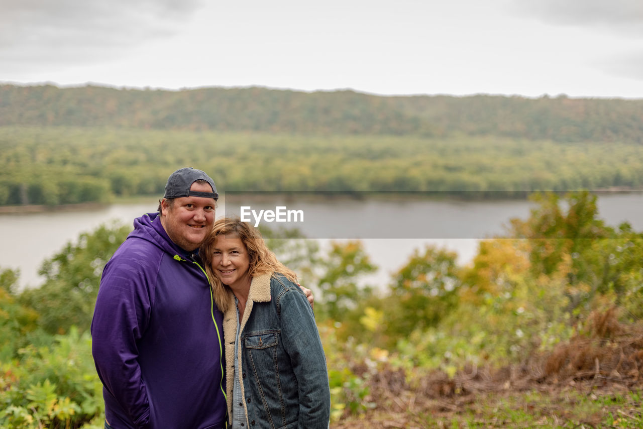 Portrait of smiling mother and son standing on field