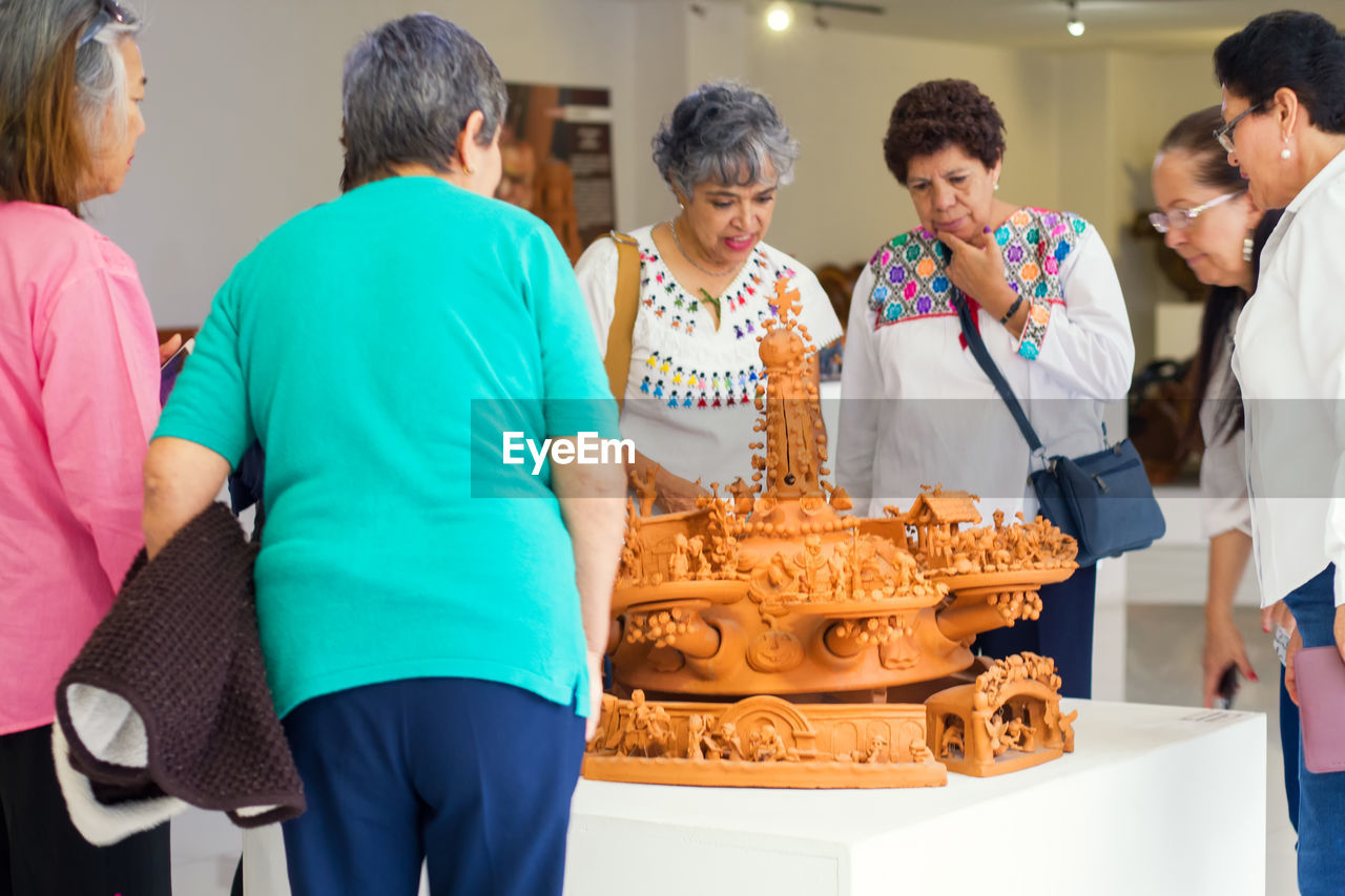 REAR VIEW OF PEOPLE STANDING IN TRADITIONAL BUILDING