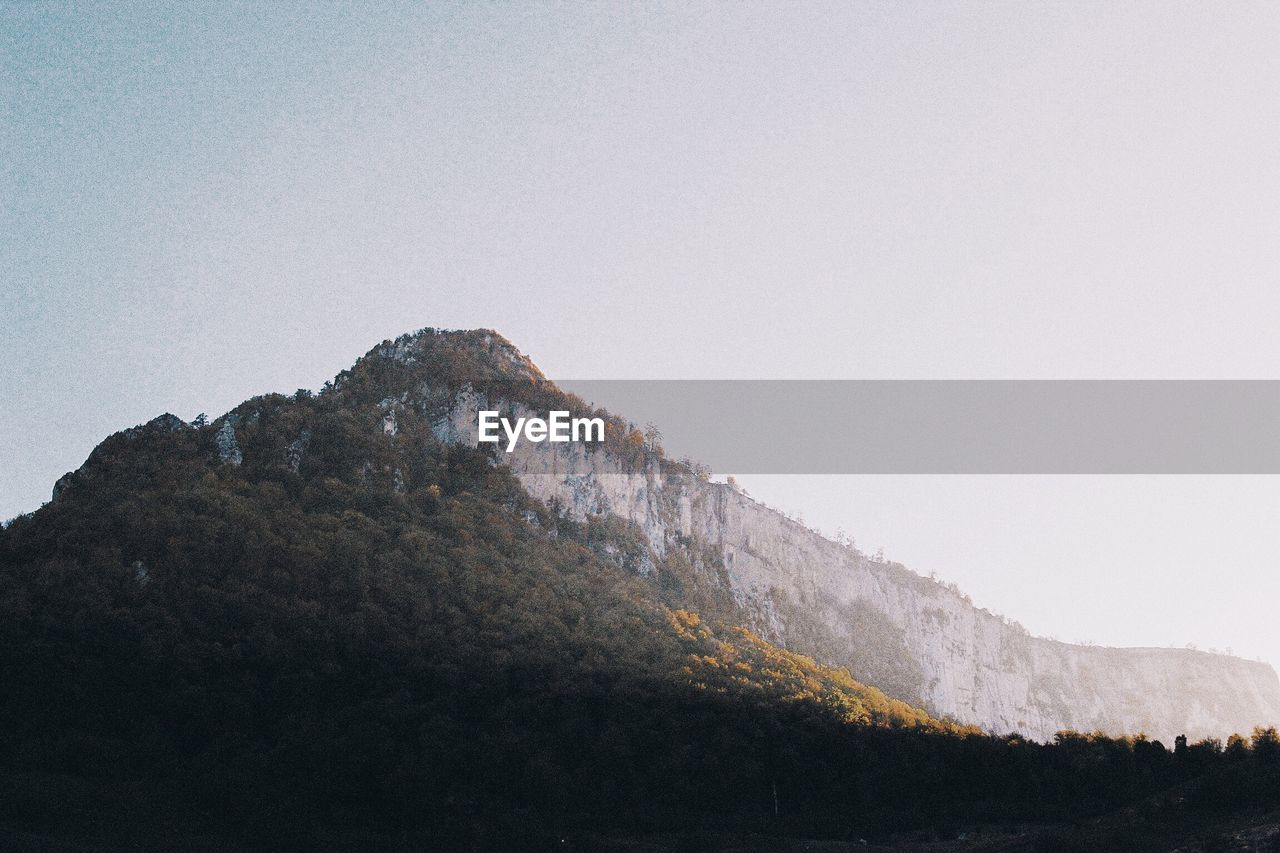 LOW ANGLE VIEW OF MOUNTAIN RANGE AGAINST CLEAR SKY