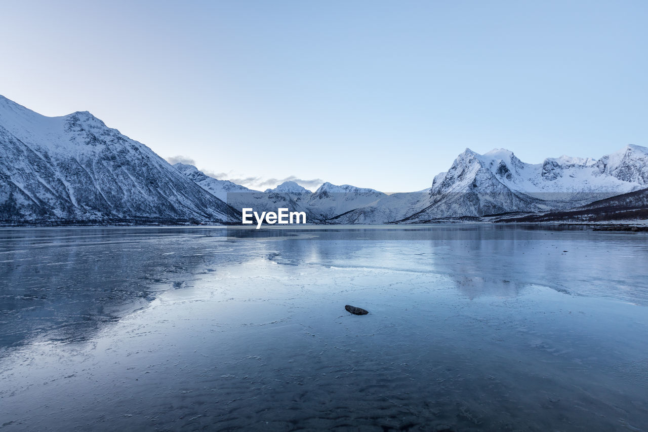 Scenic view of lake and snowcapped mountains against sky