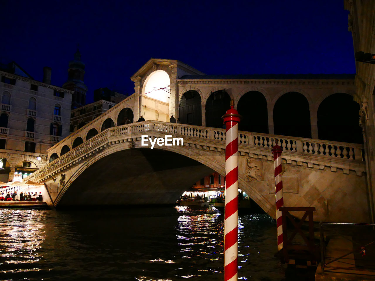 Arch bridge over river at night