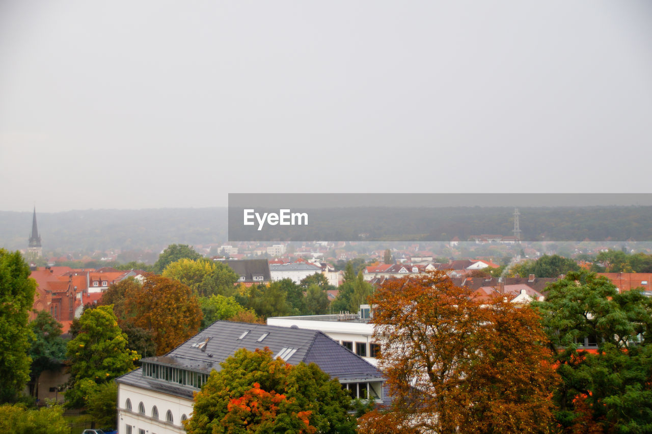 HIGH ANGLE VIEW OF TREES AND HOUSES AGAINST CLEAR SKY