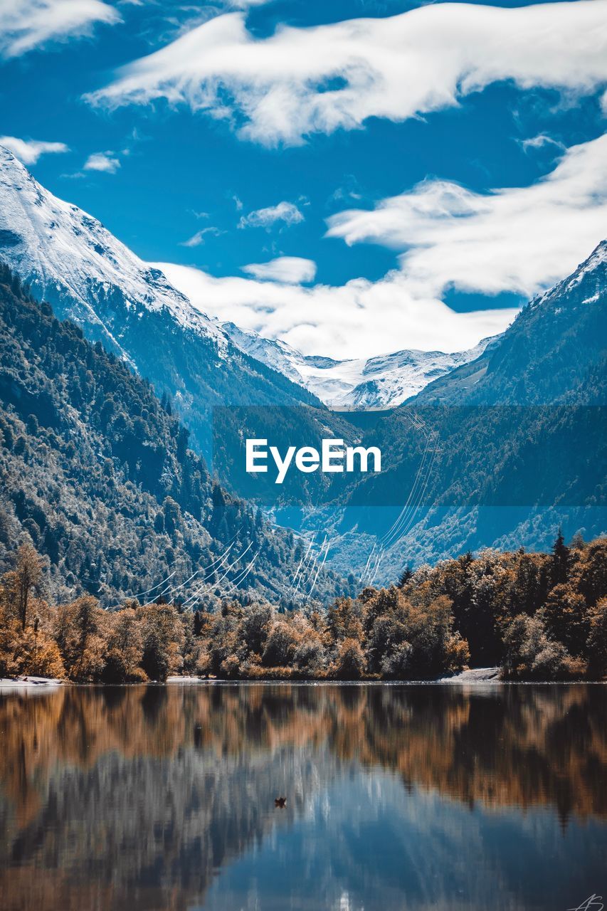 Scenic view of lake and snowcapped mountains against sky