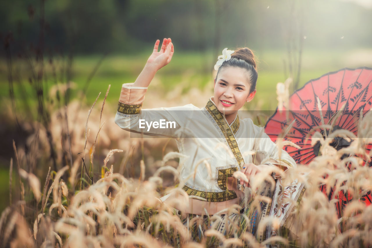 Portrait of smiling young woman on field