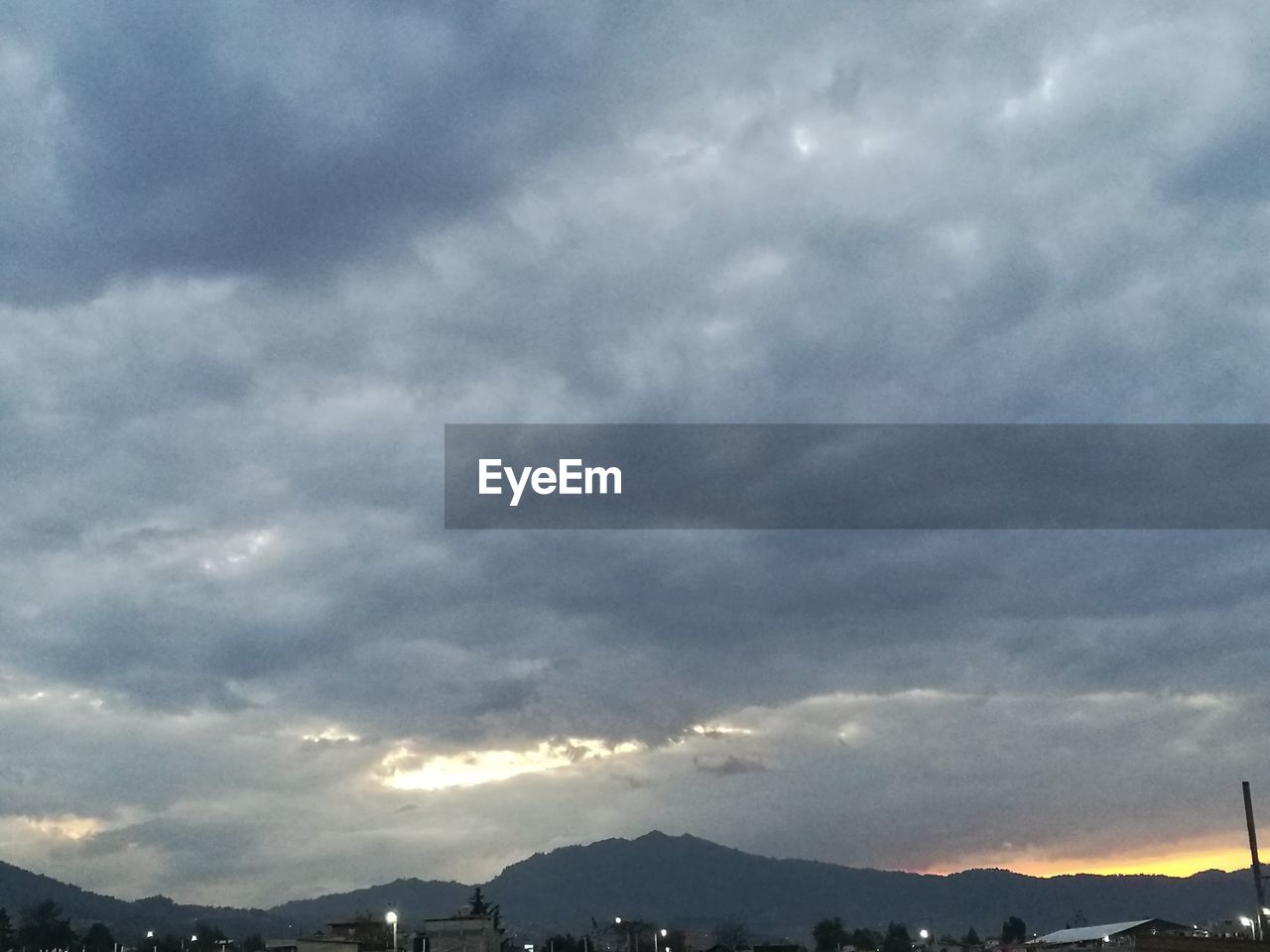 SCENIC VIEW OF SKY AND MOUNTAINS AGAINST CLOUDS IN SUNLIGHT